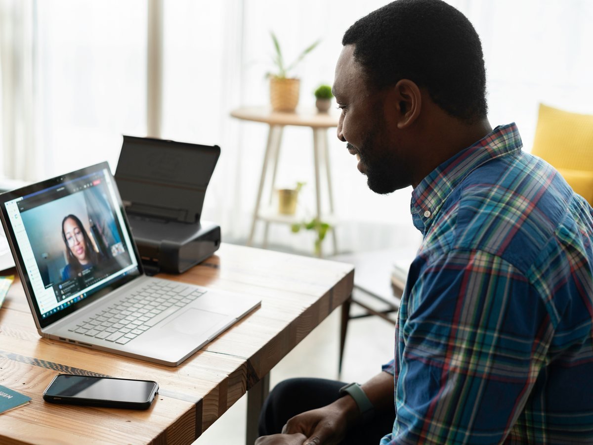 A client talking with his advisor on a video call from home